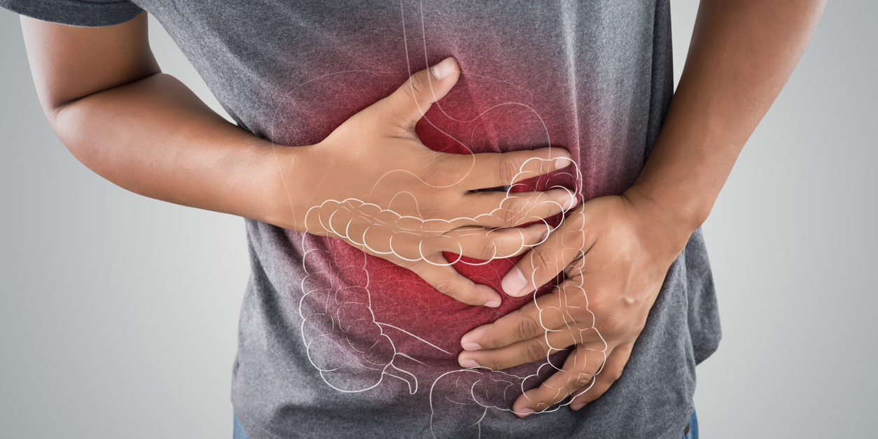 man gripping abdomen, x-ray showing lower intestine